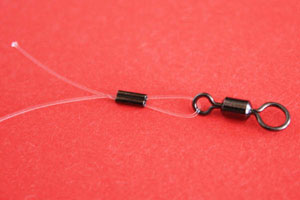 Thread link through the crimp and place the link through the eye of swivel and back through the crimp